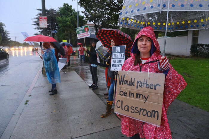 (Richard Vogel | The Associated Press)  Carrie Brown, a teacher at Los Angeles High School, braves the rain with other teachers during a city-wide teacher strike at Los Angeles High School on Monday, Jan. 14, 2019. Tens of thousands of Los Angeles teachers went on strike Monday after contentious contract negotiations failed in the nation's second-largest school district.