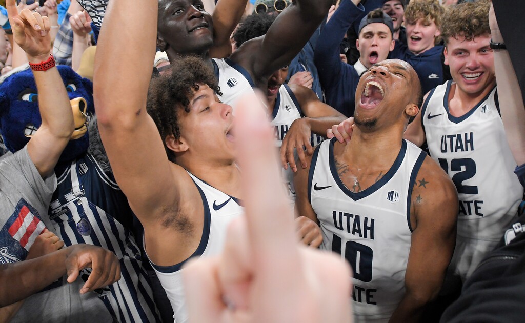 Utah State guard Javon Jackson, left, guard Darius Brown II (10) and guard Mason Falslev (12) celebrate with fans after defeating Colorado State in an NCAA college basketball game Saturday, Jan. 6, 2024, in Logan, Utah. (Eli Lucero/Herald Journal)