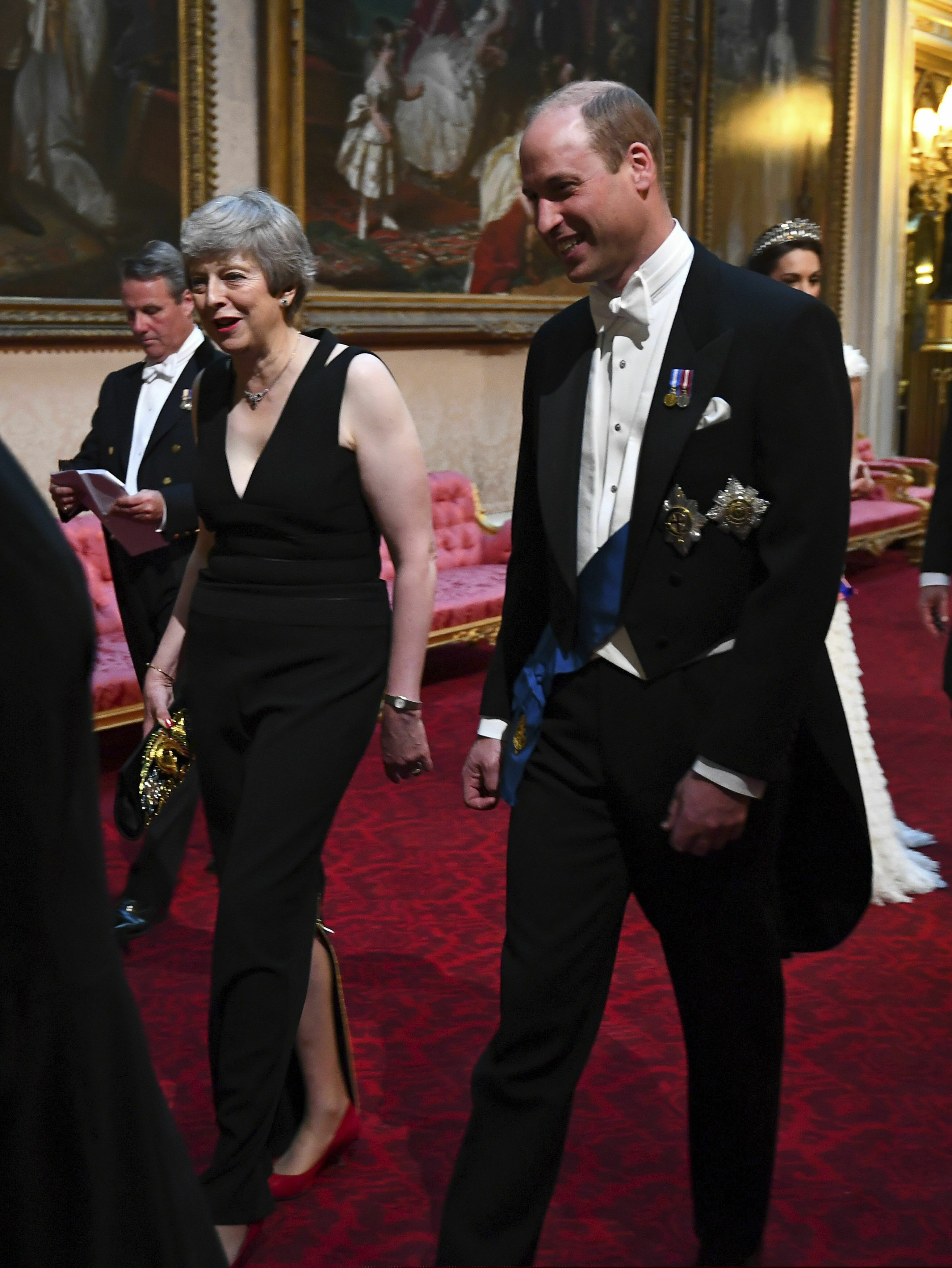 Britain's Prime Minister Theresa May, left and Prince William, Duke of Cambridge arrive through the East Gallery ahead of the State Banquet at Buckingham Palace in London, Monday, June 3, 2019.  US President, Donald Trump is on a three-day state visit to Britain. (Victoria Jones/Pool Photo via AP)