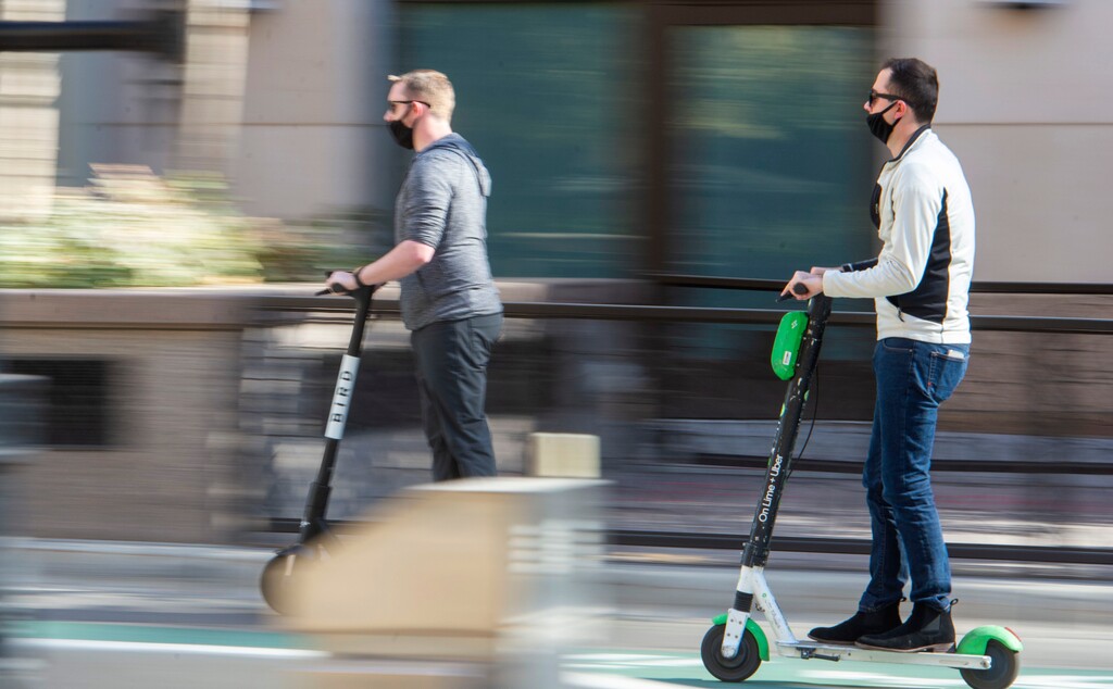 (Rick Egan | The Salt Lake Tribune)  Masked scooter riders on Main Street in Salt Lake City, Friday, Oct. 30, 2020.