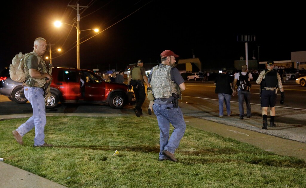 Heavily armed civilians with a group known as the Oath Keepers arrive in Ferguson, Mo., early Tuesday, Aug. 11, 2015. The far-right anti-government activists, largely consists of past and present members of the military, first responders and police officers. St. Louis County Police Chief Jon Belmar said the overnight presence of the militia group, wearing camouflage bulletproof vests and openly carrying rifles and pistols on West Florissant Avenue, the hub of marches and protests for the past several days, was "both unnecessary and inflammatory." (AP Photo/Jeff Roberson)