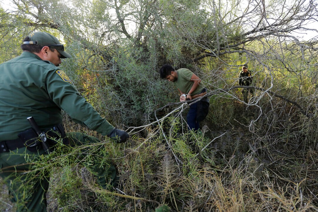 In this Wednesday, Nov. 6, 2019, photo, Border Patrol agents apprehend a man thought to have entered the country illegally, near McAllen, Texas, along the U.S.-Mexico border. In the Rio Grande Valley, the southernmost point of Texas and historically the busiest section for border crossings, the U.S. Border Patrol is apprehending around 300 people daily. That’s down from as many as 2,000 people a day in May.  (AP Photo/Eric Gay)