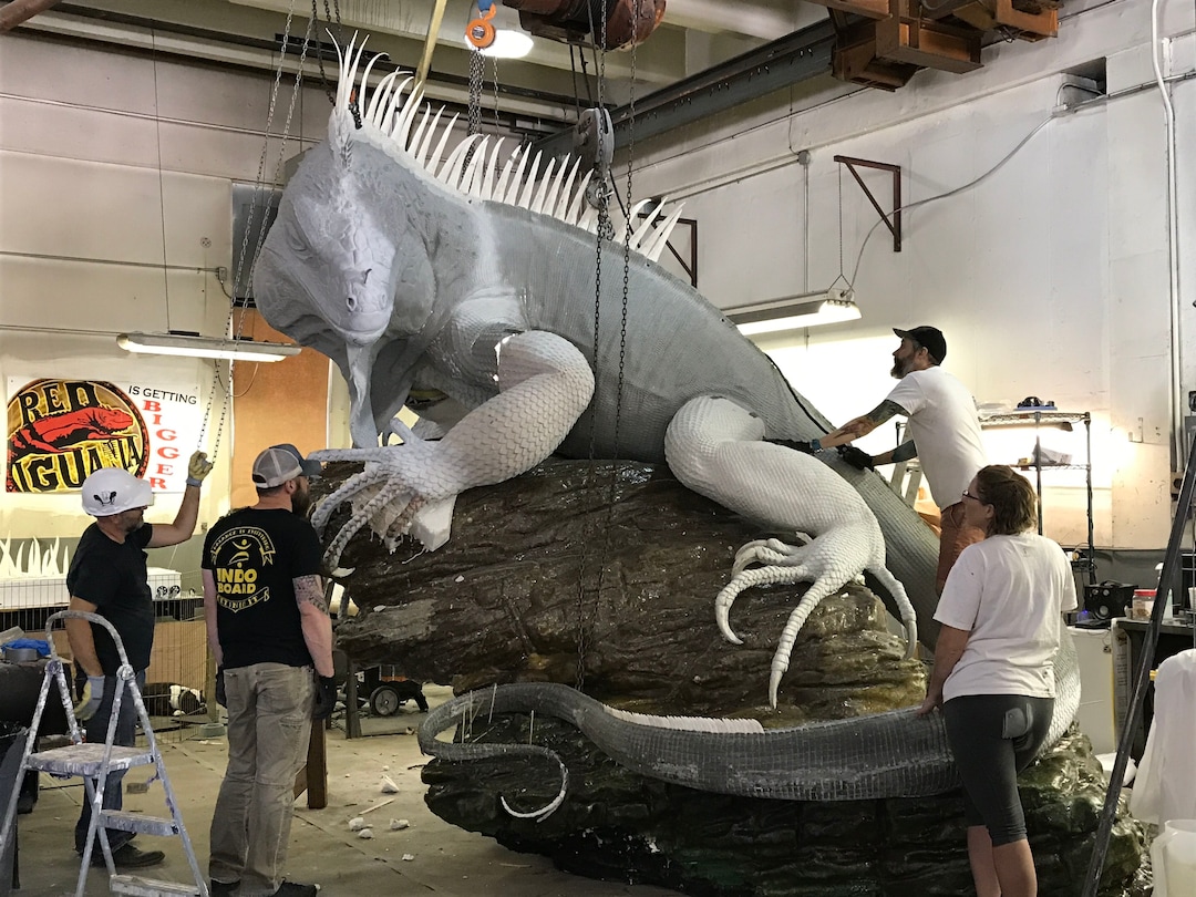 (Courtesy Red Iguana) Artist Stephen Kesler, far right, and his crew position the iguana, during the early stages of the art project.