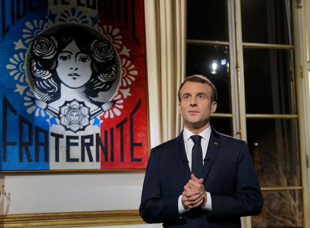 French President Emmanuel Macron, gestures as he poses for a photograph after the recording of his New Year's speech at the Elysee Palace, in Paris, Monday, Dec. 31, 2018. (AP Photo/Michel Euler, Pool)