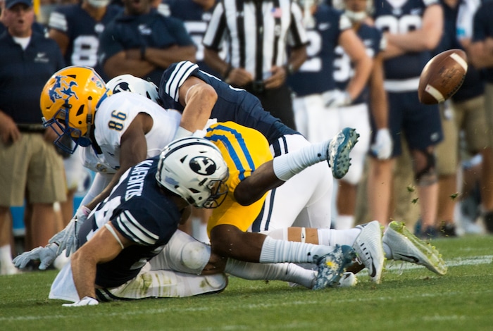 (Rick Egan  |  The Salt Lake Tribune)    Brigham Young Cougars defensive back Austin Kafentzis (24) and linebacker Nate Sampson (50), force a fumble as they hit McNeese State Cowboys wide receiver Rodnell Cruell (86), in football action Brigham Young Cougars vs McNeese State Cowboys at Lavell Edwards Stadium, Saturday, Sept. 22, 2018.


