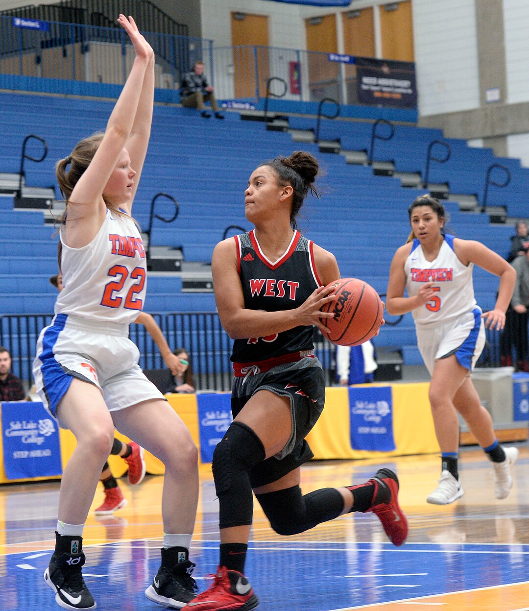 (Al Hartmann  |  The Salt Lake Tribune) 	West High School's Keisha White drives the lane against Timpview's Hannah Glazier in the Class 5 girls' basketball playoff game Monday Feb. 19 2018