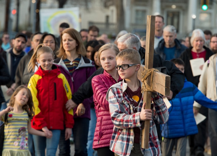 (Rick Egan  |  The Salt Lake Tribune)     Cal Burke, 11, and Grace Carlson, 12, from Layton, carry the cross as members of Christian denominations participate in the annual Good Friday procession through downtown Salt Lake City, Friday, March 30, 2018. The procession commemorating Christ's path to crucifixion has been a tradition of the Salt Lake Council of Churches since 1988. 


