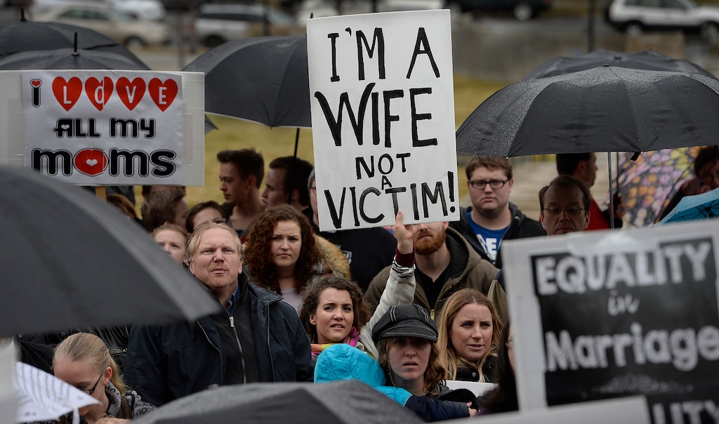 Scott Sommerdorf | The Salt Lake Tribune
April Briney, center, a plural wife, holds a sign beside her sister wife Angela Briney, right, blond hair, with other polygamists and their supporters rally on the south steps of the Capitol building, Friday, February 10, 2017.