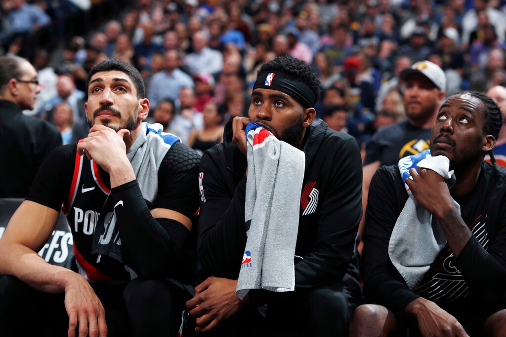 Portland Trail Blazers center Enes Kanter, forward Maurice Harkless and forward Al-Farouq Aminu, from left, watch from the bench in the waning minutes of Game 5 of the team's NBA basketball second-round playoff series against the Denver Nuggets on Tuesday, May 7, 2019, in Denver. The Nuggets won 124-98. (AP Photo/David Zalubowski)