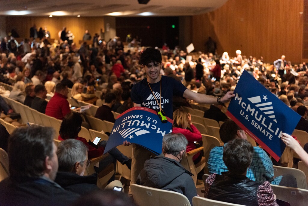 (Briana Scroggins | Special to The Tribune) Joshua Rush, a volunteer with the McMullin campaign, hands out placards during the Utah Democratic Convention at Cottonwood High School in Murray, Utah on Saturday, April 23, 2022.