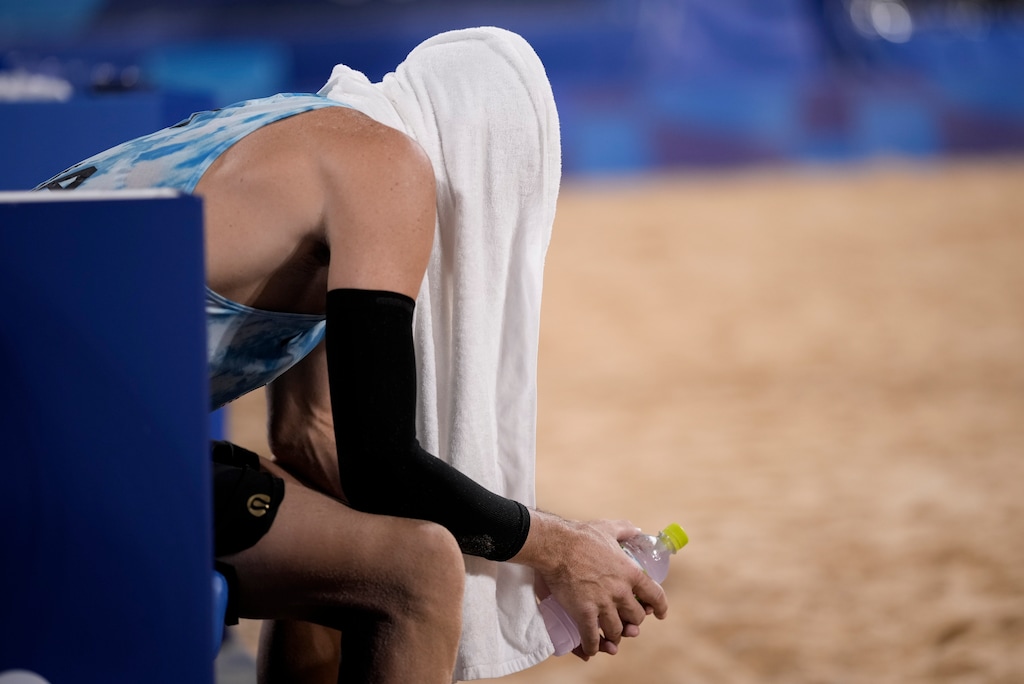 (Felipe Dana | AP) Jacob Gibb, of the United States, sits on the bench after losing to Germany in a men's beach volleyball match at the 2020 Summer Olympics, Monday, Aug. 2, 2021, in Tokyo.