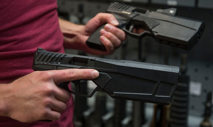 Leah Hogsten | The Salt Lake Tribune
Silencerco's public relations specialist Matt Pinnell holds both the Maxim 9 Short Configuration and the Maxin 9 Long Configuration guns inside the company's gun safe. Silencerco bills the Maxim 9 as the "world's first integrally suppressed 9mm handgun that is holster able and hearing safe with all types of 9mm ammunition." Silencerco is one of the country's largest manufacturers of silencer for guns of all kinds, Friday, May 28, 2017.