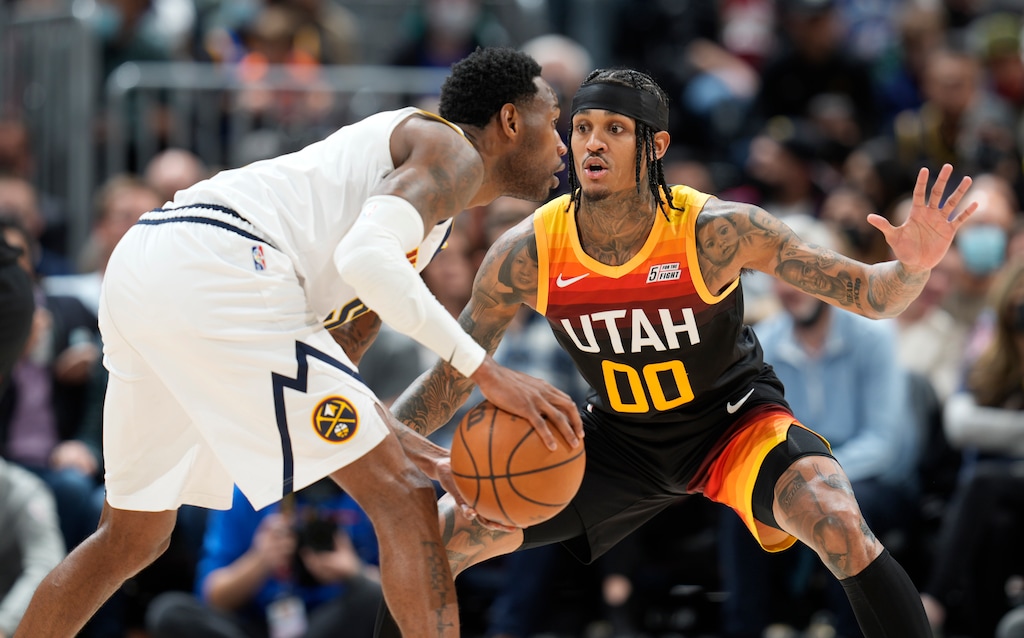 Denver Nuggets forward Will Barton, front, looks to pass the ball as Utah Jazz guard Jordan Clarkson defends in the second half of an NBA basketball game Sunday, Jan. 16, 2022, in Denver. (AP Photo/David Zalubowski)