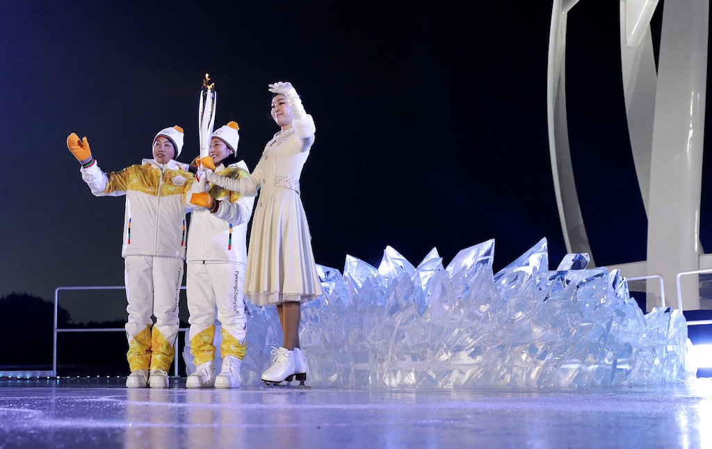 South Korean Olympic figure skating champion Yuna Kim, right, takes the tourch from North Korea's Jong Su Hyon, left, and South Korea's Park Jong-ah during the opening ceremony of the 2018 Winter Olympics in Pyeongchang, South Korea, Friday, Feb. 9, 2018. (AP Photo/David J. Phillip,Pool)