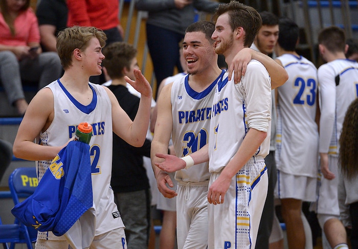 (Leah Hogsten | The Salt Lake Tribune) l-r Cyprus' Logan Hendrickson celebrates the win with teammates Tate Foote and Alex Foster. Cyprus High School boys' basketball team defeated Hillcrest High School 77-61 during their game Tuesday, January 30, 2018 in Magna.