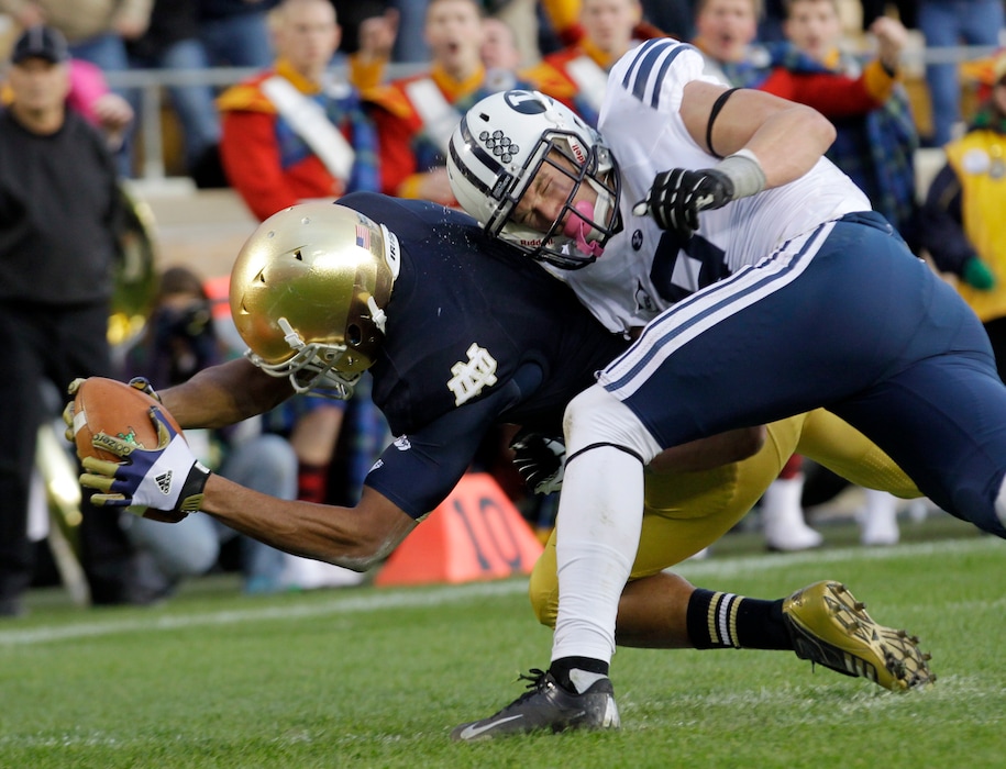 (Michael Conroy | AP) Notre Dame running back George Atkinson III is hit by BYU defensive back Daniel Sorensen as he dives in for a 20-yard touchdown run during the second half of an NCAA college football game in South Bend, Ind., Saturday, Oct. 20, 2012.