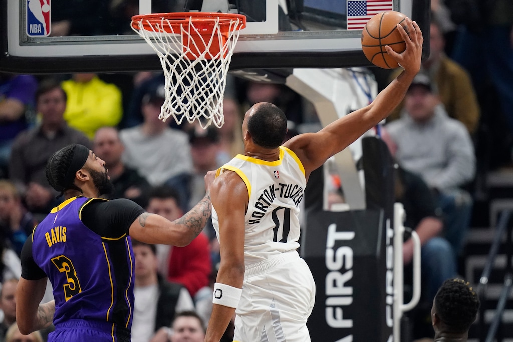 Utah Jazz guard Talen Horton-Tucker (0) dunks against Los Angeles Lakers forward Anthony Davis (3) during the first half of an NBA basketball game Tuesday, April 4, 2023, in Salt Lake City. (AP Photo/Rick Bowmer)