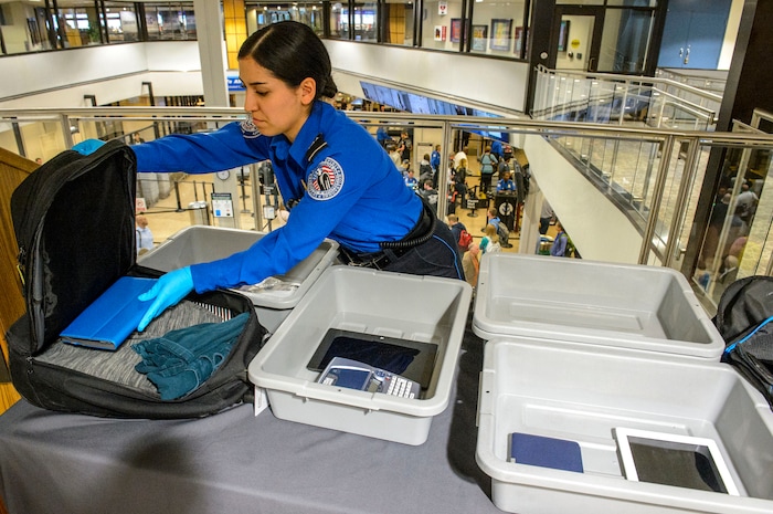 (Steve Griffin  |  The Salt Lake Tribune)  TSA agent Suzanna Coria shows some of the electronic devises that need to be in their own bin under new stronger security procedures  at the Salt Lake International Airport and five other Utah airports Thursday October 5, 2017. 