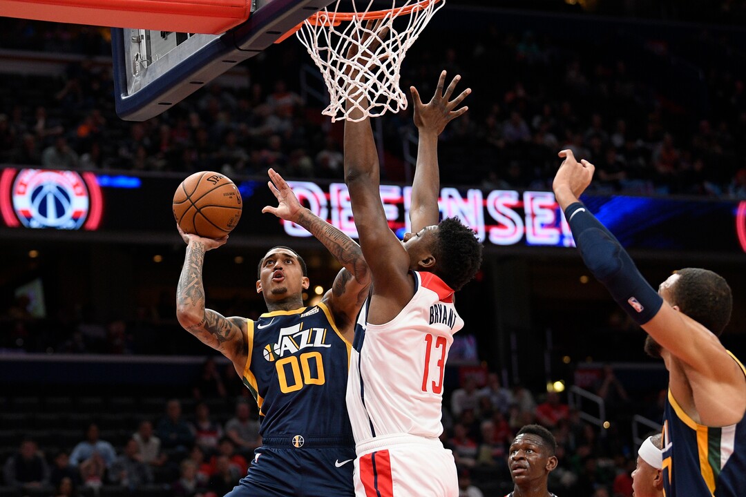 Utah Jazz guard Jordan Clarkson (00) goes to the basket next to Washington Wizards center Thomas Bryant (13) during the first half of an NBA basketball game, Sunday, Jan. 12, 2020, in Washington. (AP Photo/Nick Wass)