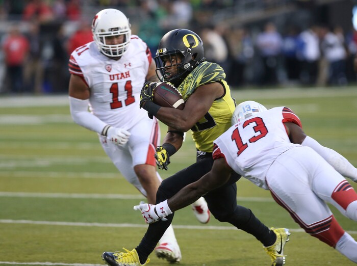 Oregon running back Kani Benoit, center, runs between Utah's Kylie Fitts, left, and Marquise Blair on his way to a touchdown during the fourth quarter of an NCAA college football game Saturday, Oct. 28, 2017, in Eugene, Ore. (AP Photo/Chris Pietsch)