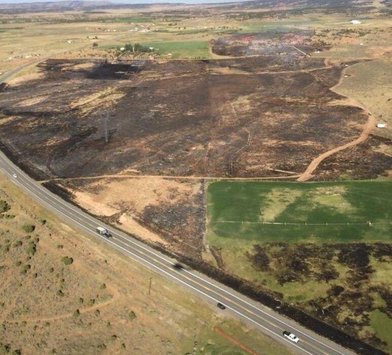 (Photo courtesy Utahfireinfo.gov) The wild land blaze dubbed the 6400 Fire smolders Aug. 9, 2020, along U.S. Highway 40 near Fruitland, Utah.