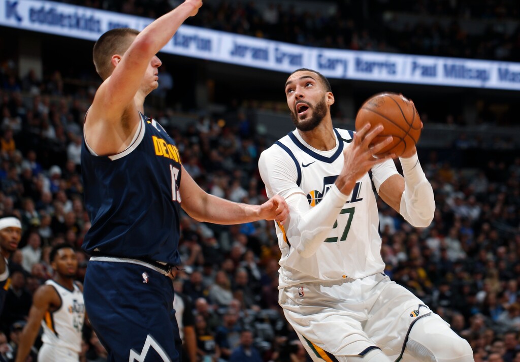 FILE - In this Jan. 30, 2020, file photo, Utah Jazz center Rudy Gobert, right, drives to the rim as Denver Nuggets center Nikola Jokic defends in the second half of an NBA basketball game in Denver. (AP Photo/David Zalubowski, File)