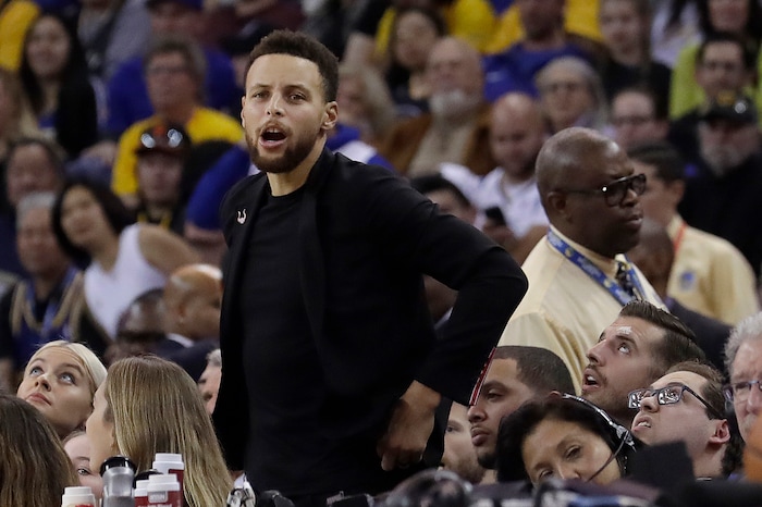 Injured Golden State Warriors guard Stephen Curry watches from the bench during the first half of the team's NBA basketball game against the Utah Jazz in Oakland, Calif., Wednesday, Dec. 27, 2017. (AP Photo/Jeff Chiu)