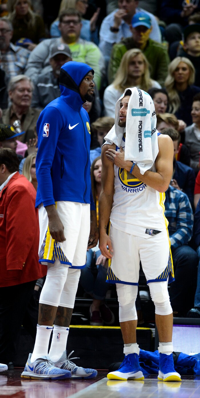 (Steve Griffin  |  The Salt Lake Tribune) Golden State Warriors forward Kevin Durant (35) snf Golden State Warriors guard Stephen Curry (30) keep warm on the bench as they sit out the fourth quarter as the Jazz build a huge lead during the Utah Jazz versus Golden State Warriors at Vivint Smart Home Arena in Salt Lake City Tuesday January 30, 2018.