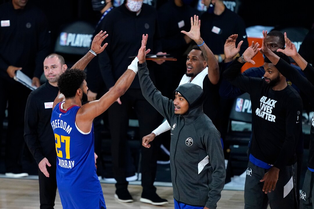 Denver Nuggets' Jamal Murray (27) celebrates with teammates after an NBA basketball first round playoff game against the Utah Jazz Sunday, Aug. 30, 2020, in Lake Buena Vista, Fla. The Nuggets won 119-107. (AP Photo/Ashley Landis)
