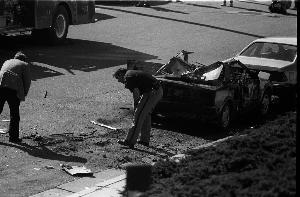 (Tribune file photo) Investigators examine Mark Hofmann's blown-up car in 1985.