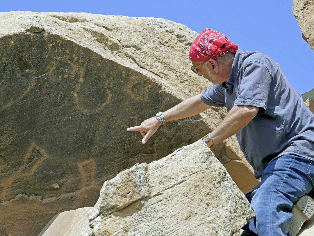 (History Channel) Archaeologist Dr. Alan Garfinkel inspects the petroglyph on a rock base found in Skinwalker Ranch, in a moment from History’s series “The Secret of Skinwalker Ranch.”
