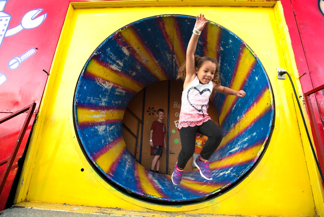 (Rick Egan  |  The Salt Lake Tribune)  Mariah Forman, 5, leaps out of the Barrel of Fun, at the Utah State Fair,  Monday, September 11, 2017.
