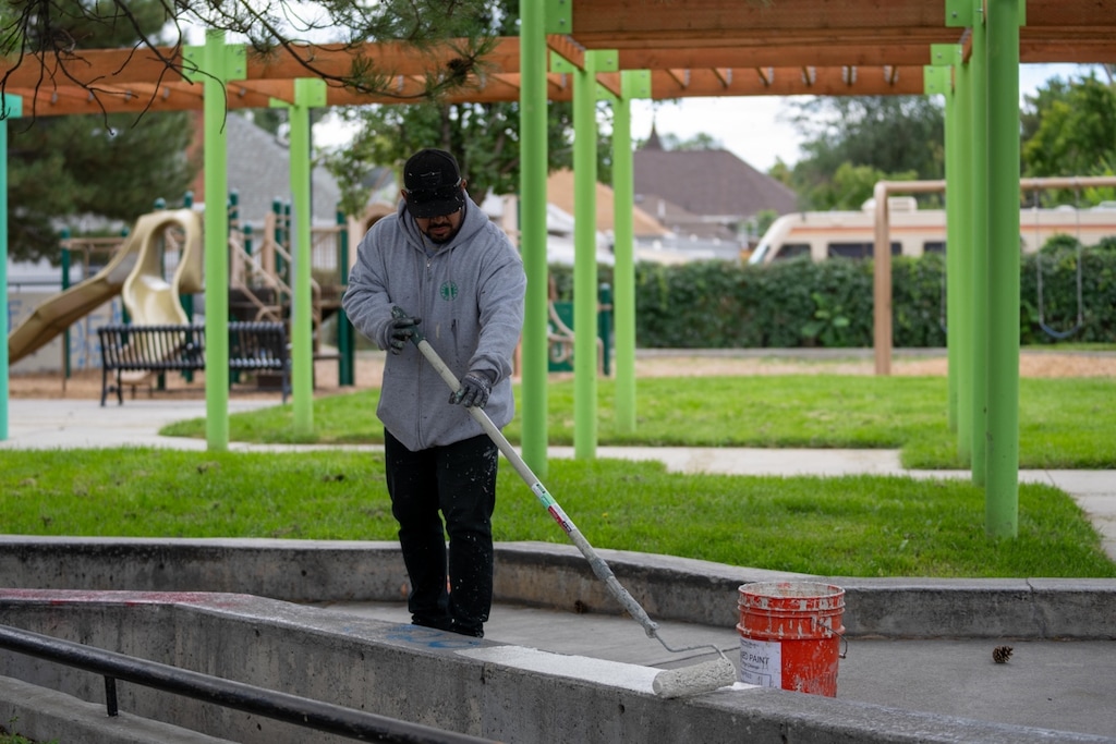 (SLCPD) A Salt Lake City Parks employee cleans up on Saturday, Sept. 2, 2023, after police say two men caused extensive gang-related damage at Jackson Park.