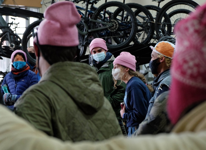 (Francisco Kjolseth  | The Salt Lake Tribune) People gather in a big circle at Hangar 15 bicycle shop in Millcreek to tell stories of Louis Holian, Sarah Moughamian and Thomas Steinbrecher on Sunday, Feb. 14, 2021, three of the four who died in an avalanche on Saturday, Feb. 6. Louis who loved the color pink was honored by many wearing pink hats. Stephanie Hopkins who was in a different group that day was swept up in the same avalanche.