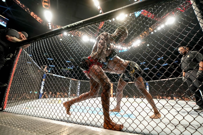 (Francisco Kjolseth | The Salt Lake Tribune) UFC fighter Leon Edwards, of Jamaica, left, is pressed against the fence by Nigerian UFC fighter Kamaru Usman of Nigeria during their welterweight UFC 278 mixed martial arts title bout in Salt Lake City on Saturday, Aug. 20, 2022.