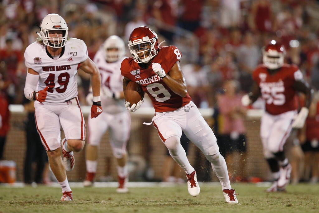 (Sue Ogrocki | AP) In this Saturday, Sept. 7, 2019, file photo, Oklahoma wide receiver Trejan Bridges (8) carries past South Dakota linebacker Brock Mogensen (49) in the fourth quarter of an NCAA college football game in Norman, Okla.