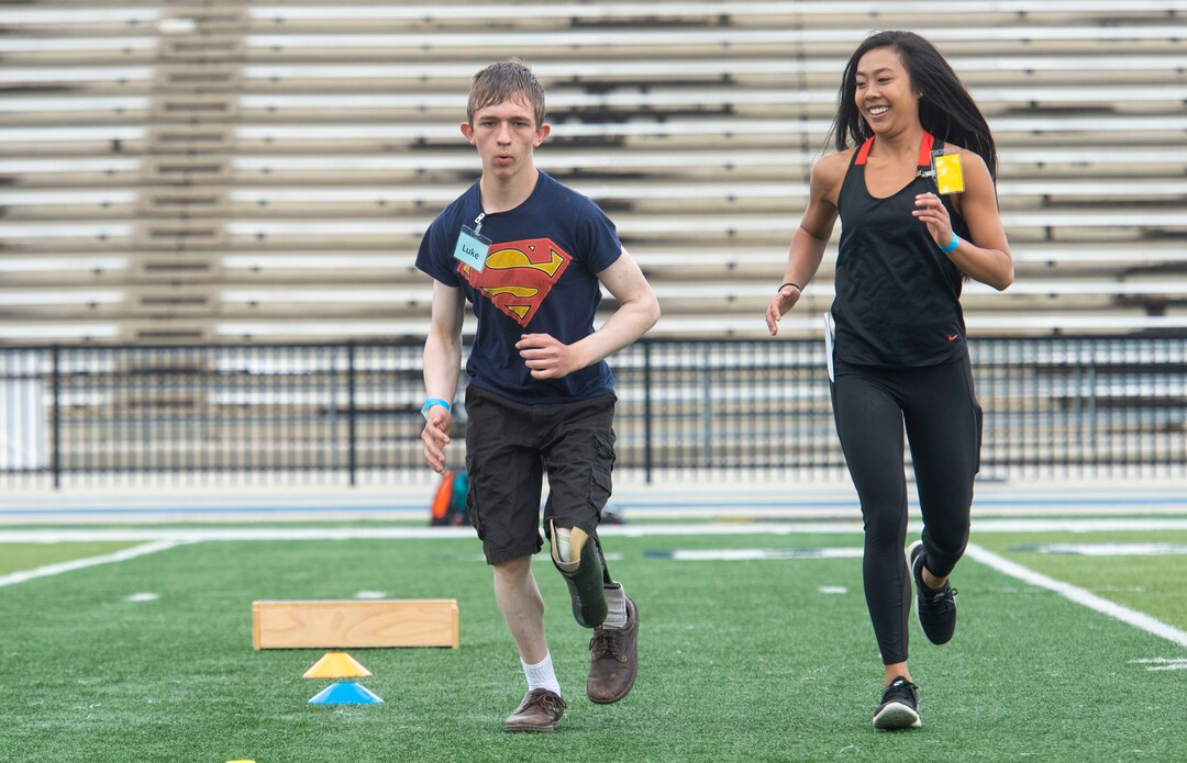 (Rick Egan  |  The Salt Lake Tribune)     Luke Pratt, from Cove Fort, runs with Teagan Young, a physical therapy student at the University of Utah, during the fourth annual Utah Adaptive Mobility Clinic at Skyline High school. The clinic allows anyone with "lower extremity limb loss or limb difference" or amputees without legs, to practice walking and running. Saturday, June 1, 2019.