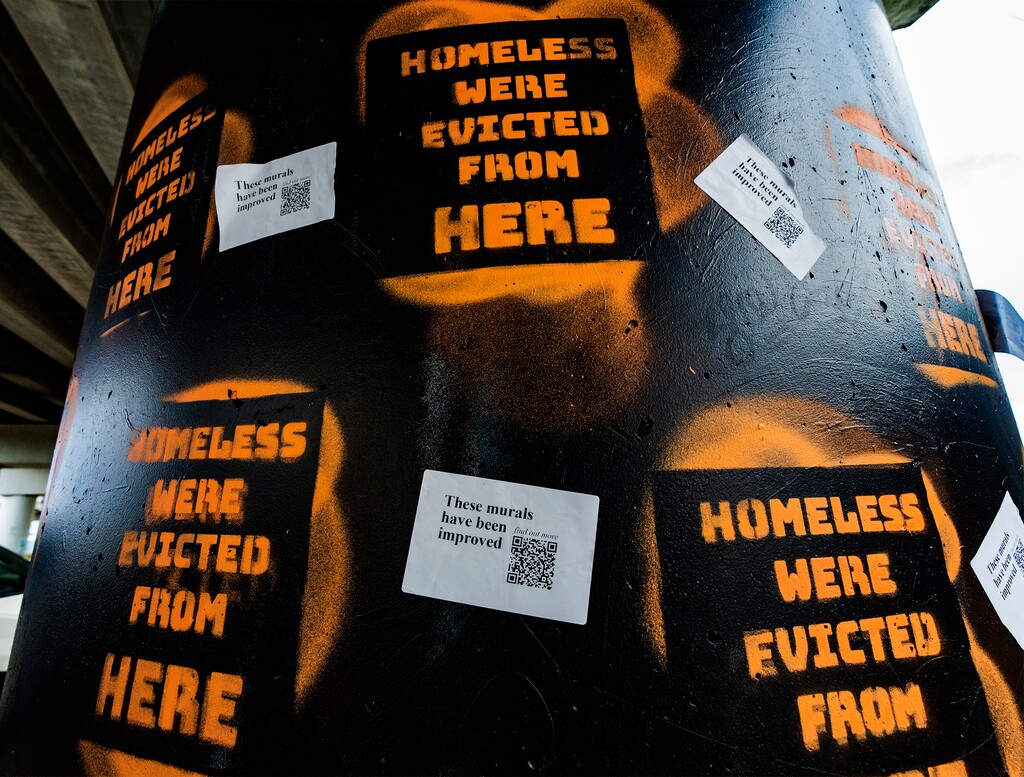 (Rick Egan | The Salt Lake Tribune) Graffiti saying "Homeless were evicted from here" obscures art from the 9 Pillars Mural Project under the 600 South/Interstate 15 offramp on Thursday, July 14, 2022.