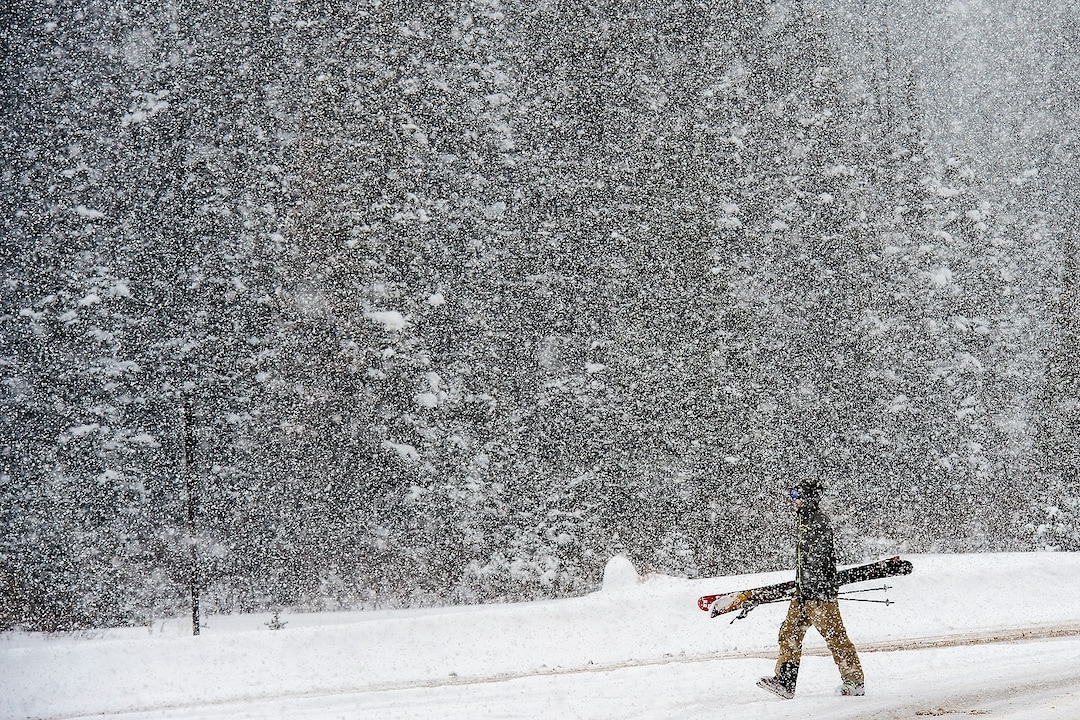 (Chris Detrick  |  The Salt Lake Tribune) A skier walks along South Brighton Loop Road in Brighton Saturday, December 23, 2017.  