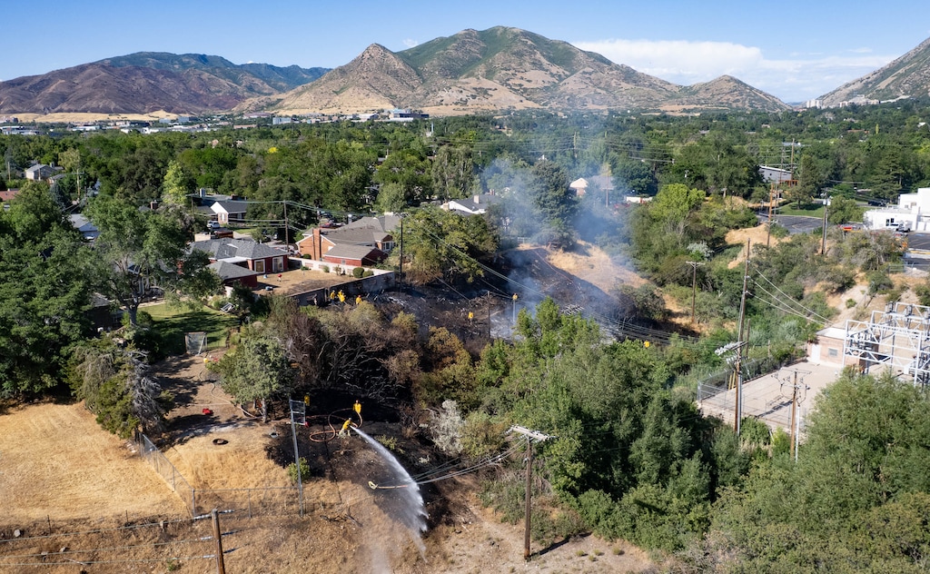 (Francisco Kjolseth | The Salt Lake Tribune) Wasatch Hollow near Clayton Middle School in Salt Lake City burns, threatening homes on Harrison Ave., Wednesday, July 8, 2026.