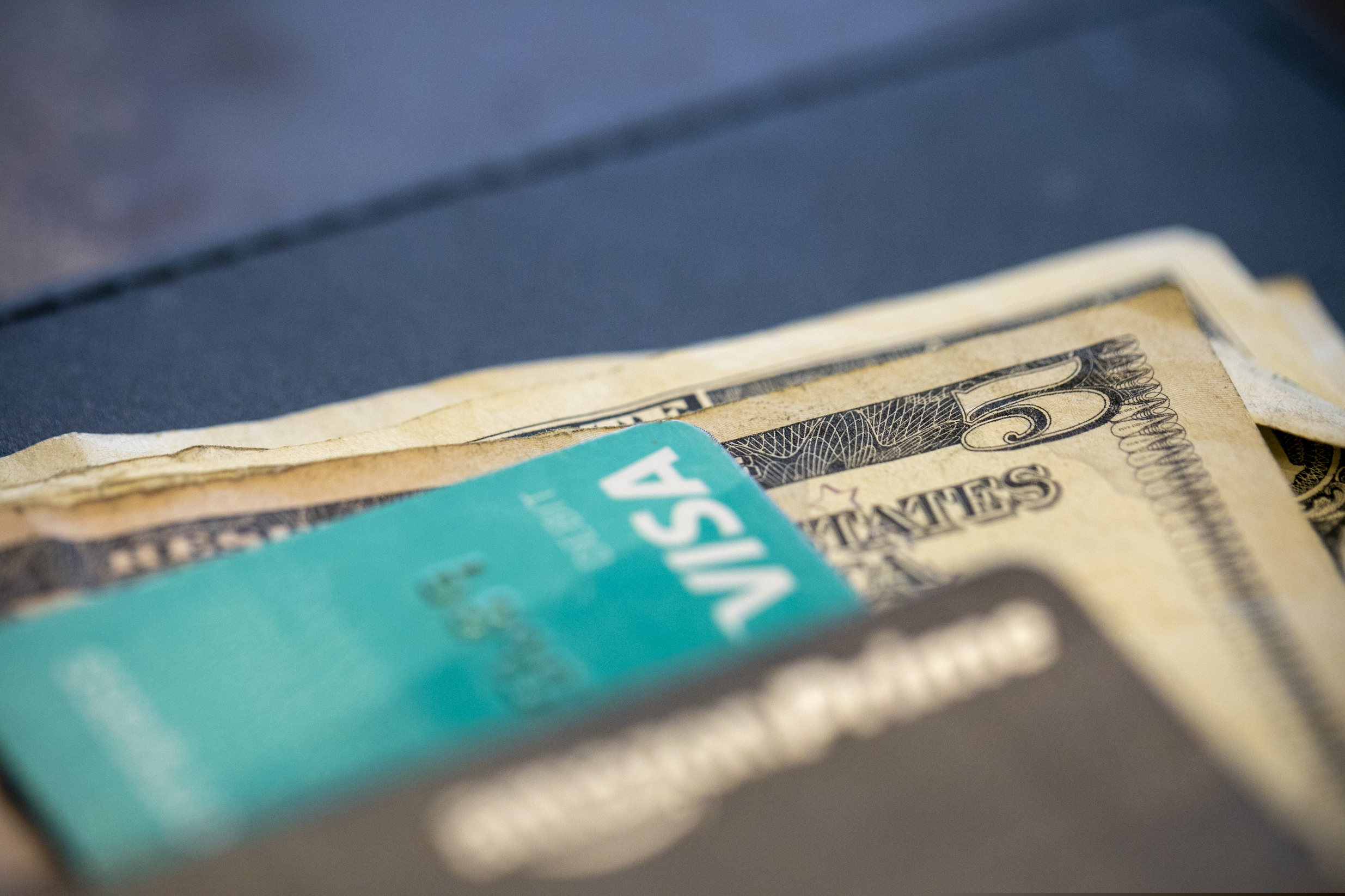 (Jenny Kane | The Associated Press) In this Aug. 11, 2019, photo, U.S. currency and credit cards sit on a table at a restaurant.