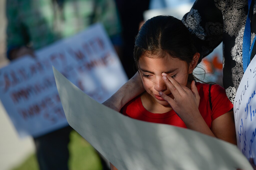 (Francisco Kjolseth  |  The Salt Lake Tribune)  Sarai Reyes, 9, cries as she speaks with the help of her 4th grade teacher while surrounded by community members who gathered in front of Immigration and Customs Enforcement offices in West Valley City on Monday, Oct. 16, 2017, to support Maria Santiago Garcia, a single Utah mother of four U.S. born children who faces an impending deportation order.