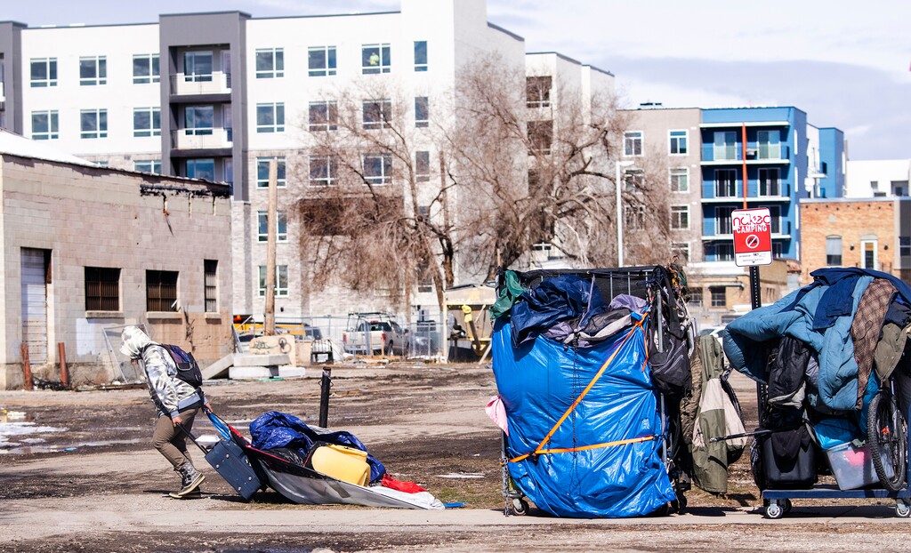 (Rick Egan | The Salt Lake Tribune) Groups of unsheltered people move their belongings after a camp clearing in Salt Lake City in March. As federal funding for homelessness support services decreases, the rate of homelessness in Utah, meanwhile, has continued to tick up.