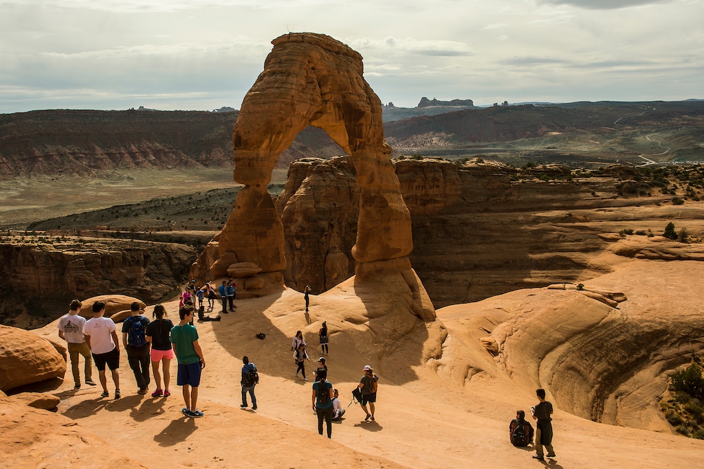 (Chris Detrick  |  Tribune file photo) Visitors take pictures and hike around Delicate Arch in Arches National Park Saturday March 5, 2016. 