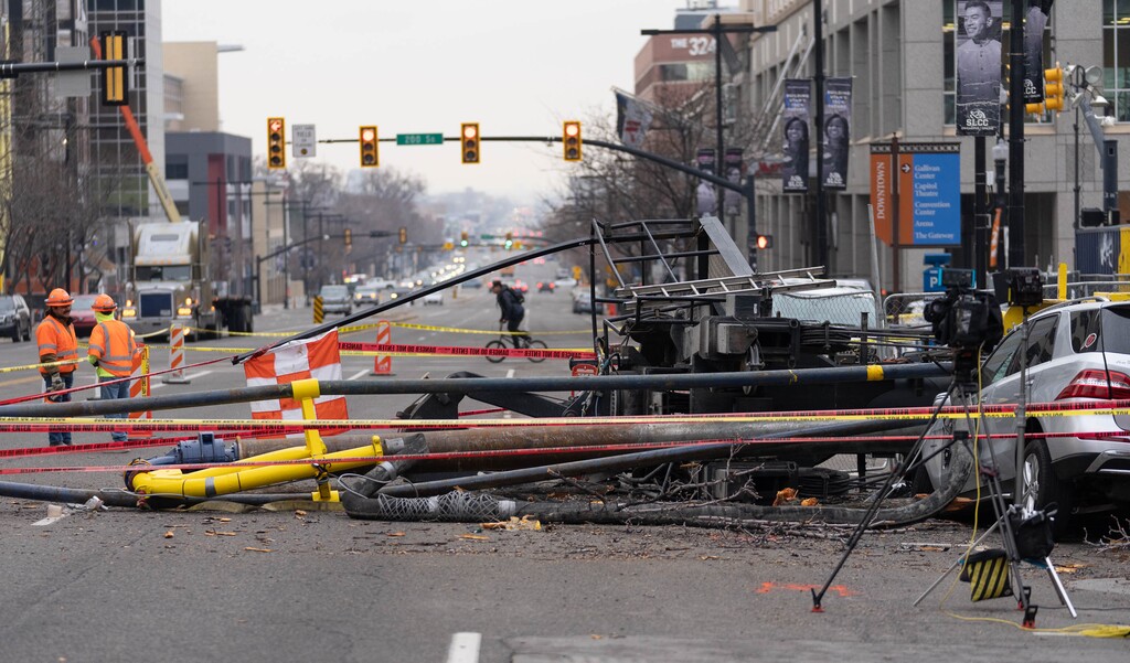 (Francisco Kjolseth | The Salt Lake Tribune) Crews survey the damage of a collapsed drill rig as seen on Wednesday, March 16, 2022, at the intersection of State Street and 200 South. The rig toppled over Tuesday night at the site of the new Astra Tower, crushing two unoccupied parked cars and sending the crane operator to the hospital in serious condition.