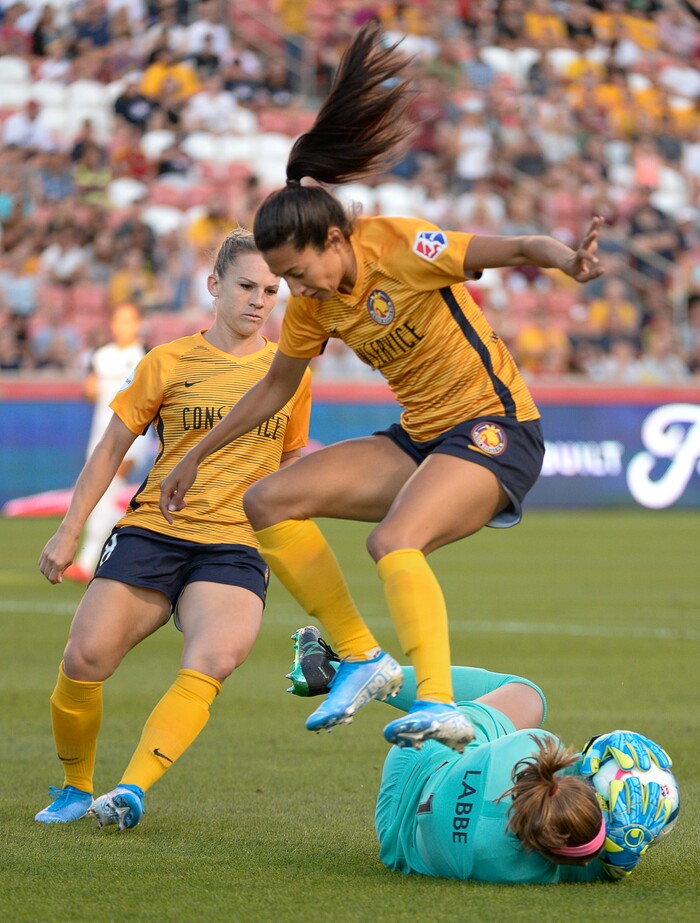 (Francisco Kjolseth  |  The Salt Lake Tribune)  Utah Royals FC forward Christen Press (23) leaps over North Carolina Courage goalkeeper Stephanie Labb (1) as Utah Royals FC hosts the North Carolina Courage at Rio Tinto Stadium in Sandy, Utah on Saturday, July 27, 2019.