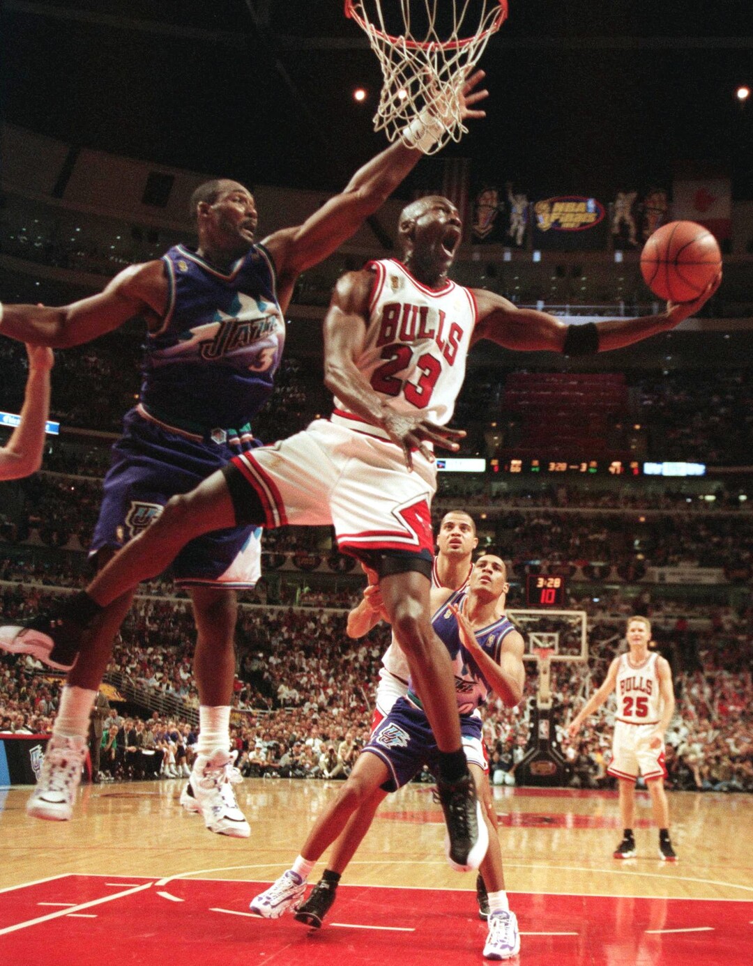 (AP file photo) The Chicago Bulls' Michael Jordan goes up and under Utah Jazz forward Karl Malone as he drives to the hoop during the third quarter of Game 2 in the NBA Finals on June 4, 1997, in Chicago.