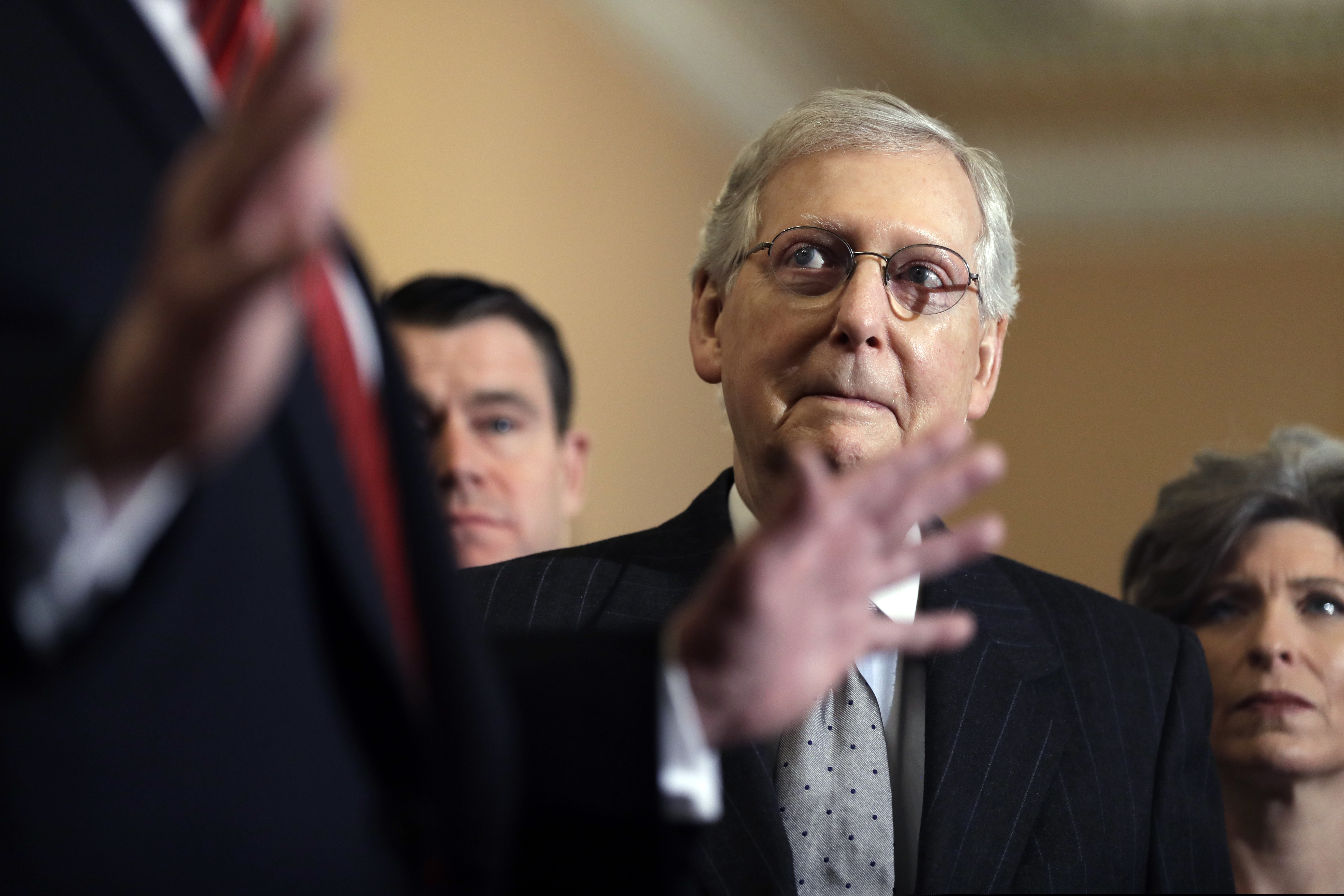 Senate Majority Leader Mitch McConnell of Ky., listens as President Donald Trump talks to the media after a Senate Republican policy lunch on Capitol Hill, Wednesday, Jan. 9, 2018, in Washington. At right is Sen. Joni Ernst, R-Iowa. (AP Photo/ Evan Vucci)