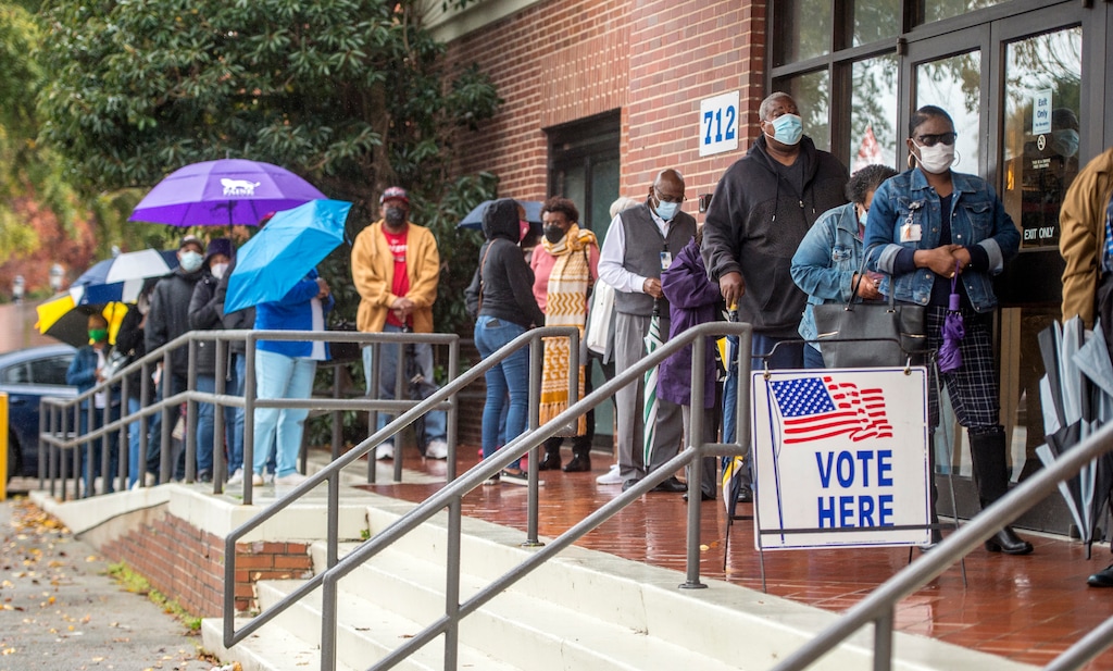 (Michael Holahan | The Augusta Chronicle via AP) - In this Dec. 14, 2020, file photo, people wait in line on the first day of advance voting for Georgia's Senate runoff election at the Bell Auditorium in Augusta, Ga. Utah Republican officeholders are busily raising money for the election, which will determine which party controls the Senate.