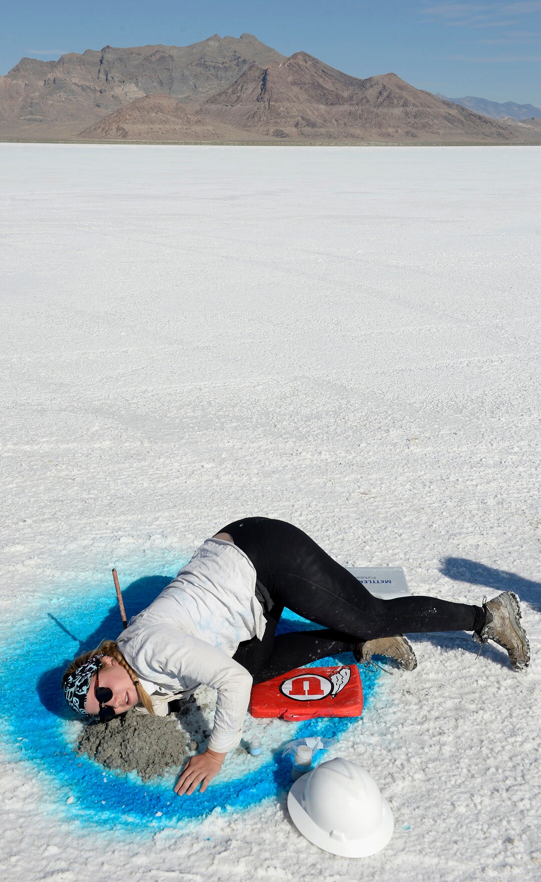 (Al Hartmann  |  Tribune file photo) University of Utah undergraduate research assistant Lily Wetterlan reaches far down a drilled bore hole in the Bonneville Salt Flats on Sept. 6, 2017, and scoops out salt brine to test. University of Utah scientists are studying the degradation of the Bonneville Salt Flats and are making 70 exploratory bore holes and taking measurements of salt crust thickness and composition.